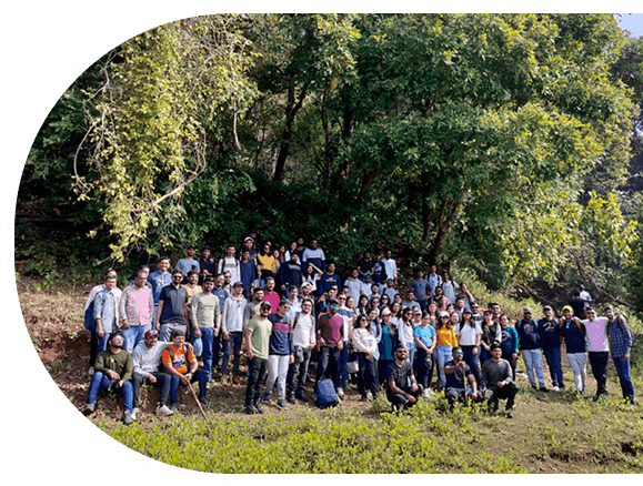 A diverse group of employees at one of the best IT company in Surat, smiling together at the picnic showcasing company culture.